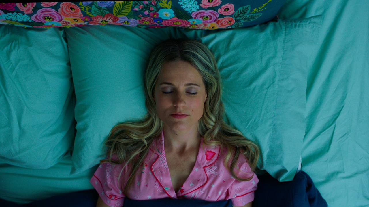 BRAINSOMNIAC film still with pink and amber bedroom tones.